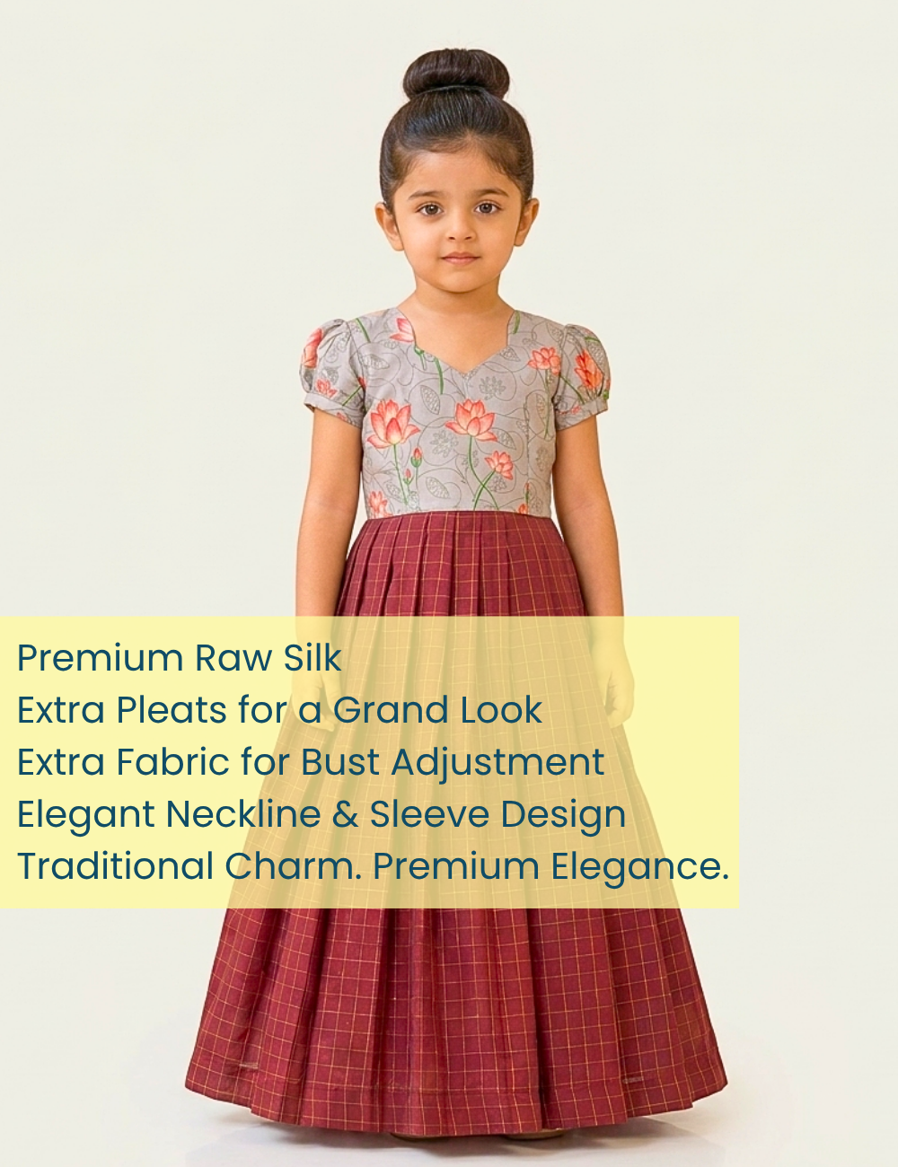 A young girl modeling a traditional Indian dress made of premium raw silk, featuring a gray floral top and a red checkered pleated skirt, set against a plain light background with a yellow text banner overlay.